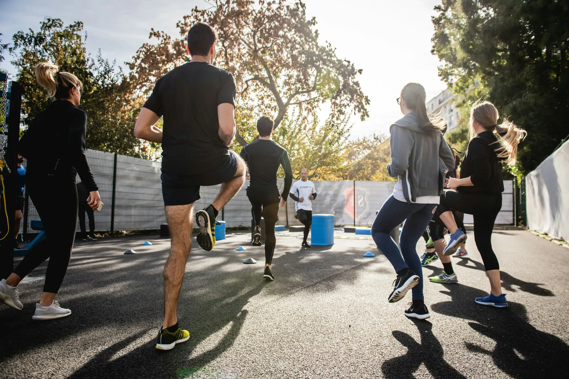 Group running session outdoors showing diverse participants jogging together, illustrating community-based coaching and collective fitness motivation.