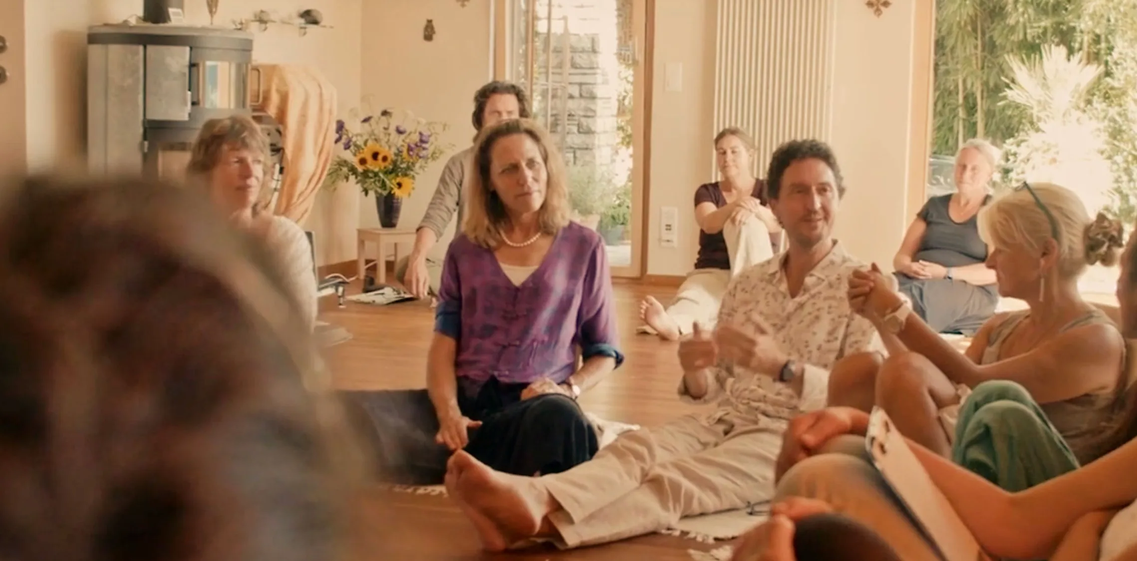 Frau sitzt meditierend in der Natur und strahlt innere Ruhe und Freude aus, symbolisiert seelenzentriertes Coaching und inneren Kompass