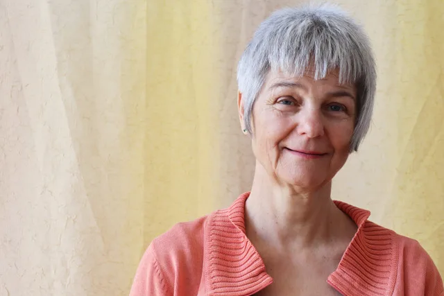 Frau in meditativer Haltung mit geschlossenen Augen, umgeben von warmem Licht, symbolisiert innere Balance und Aktivierung der Selbstheilungskräfte